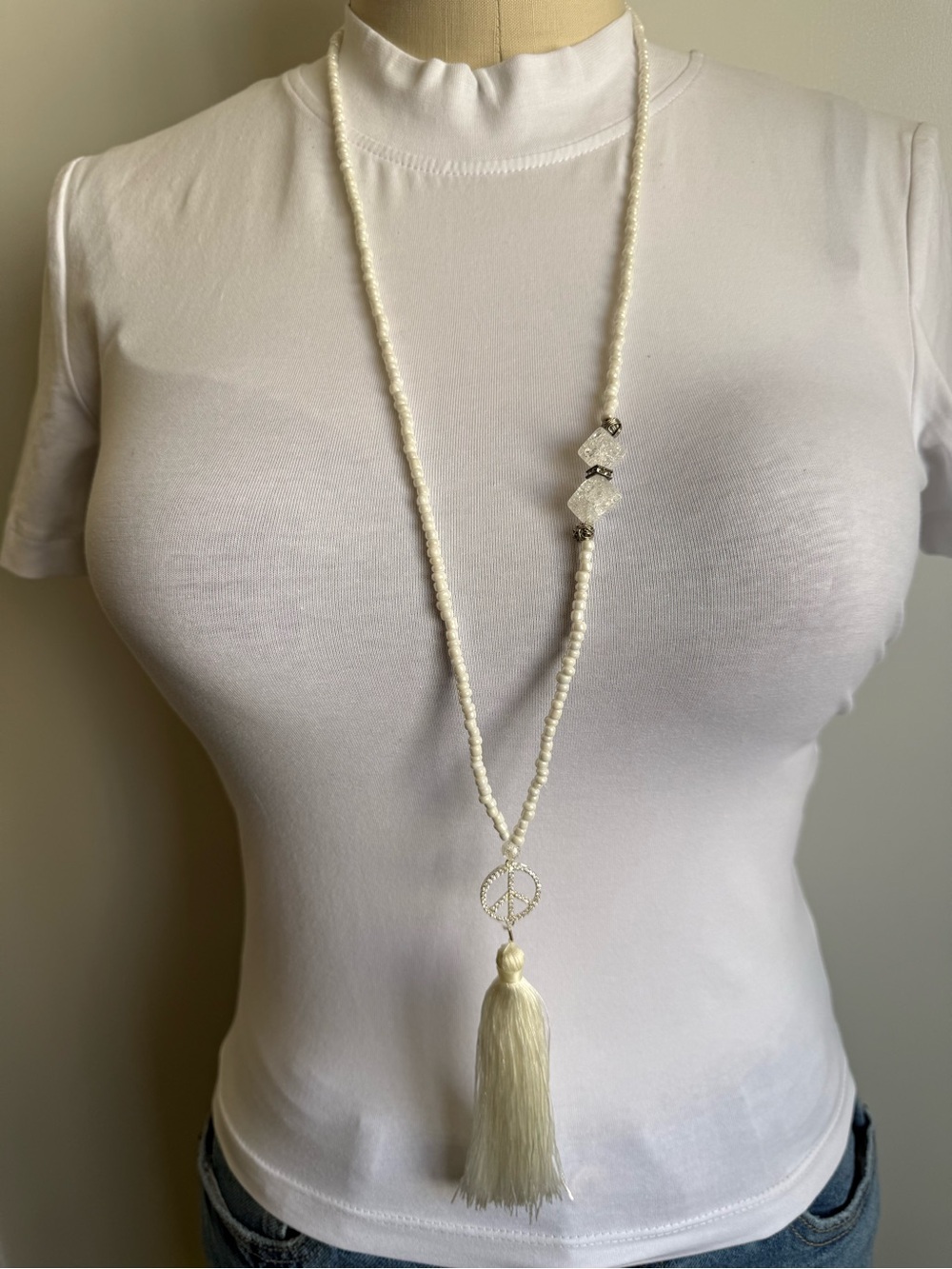 Elegant White Beaded Tassel Necklace with Peace Charm